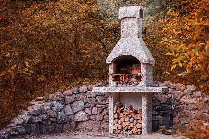 Un barbecue en pierre dans un jardin d'automne