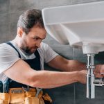 Un plombier qui répare un lavabo