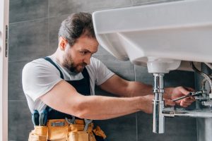 Un plombier qui répare un lavabo